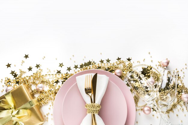 Ajuste da tabela do natal com dishware cor-de-rosa, pratas dourada no branco. vista do topo.
