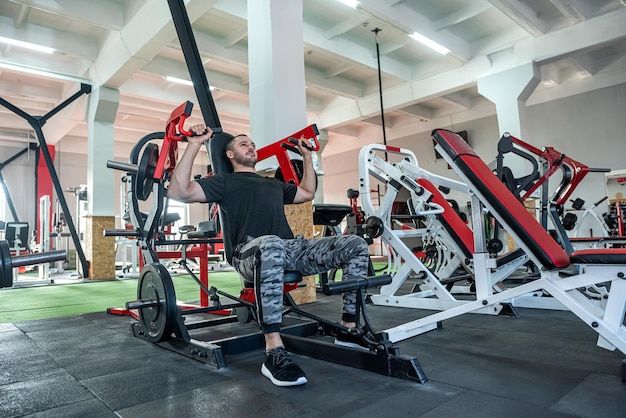 Ajuste joven caucásico haciendo ejercicio en el concepto de deporte de gimnasio