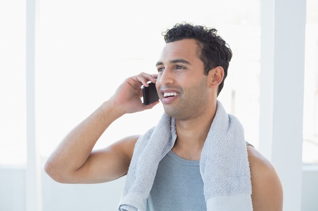 Ajuste joven sonriente con teléfono móvil