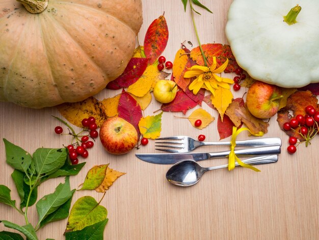 Ajuste de lugar temático de otoño o otoño con un cuchillo, cuchara y tenedor, hojas coloridas, espacio de copia para texto