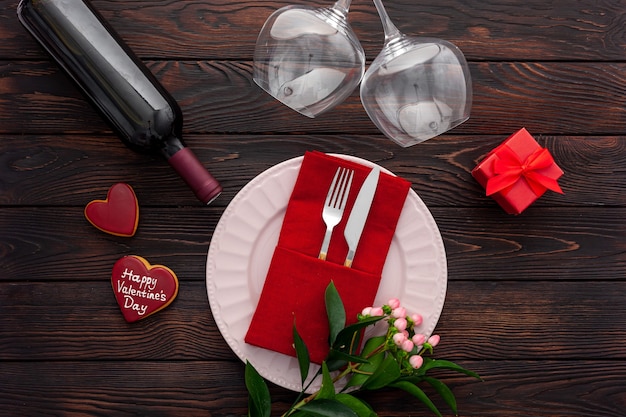 Foto ajuste de la mesa del día de san valentín con plato, vino y copas