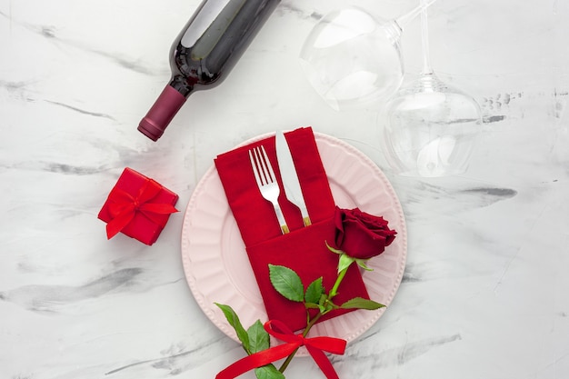 Ajuste de la mesa del día de San Valentín con plato, vino y copas