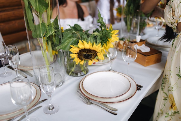 Ajuste de la mesa hermosos platos blancos cubiertos de plata y vasos de cristal fiesta al aire libre en vacaciones