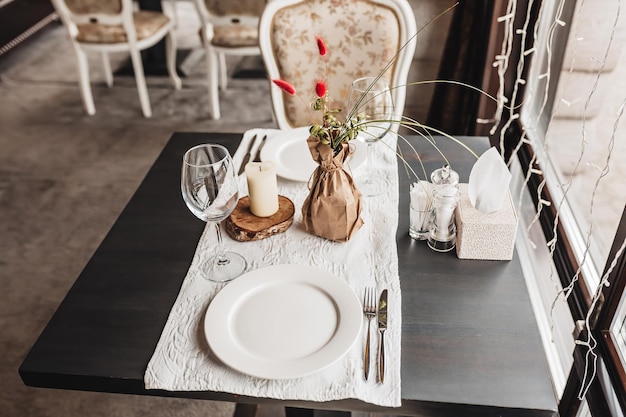 Ajuste de mesa de lujo para parejas cenando en un restaurante en colores pastel de cerca