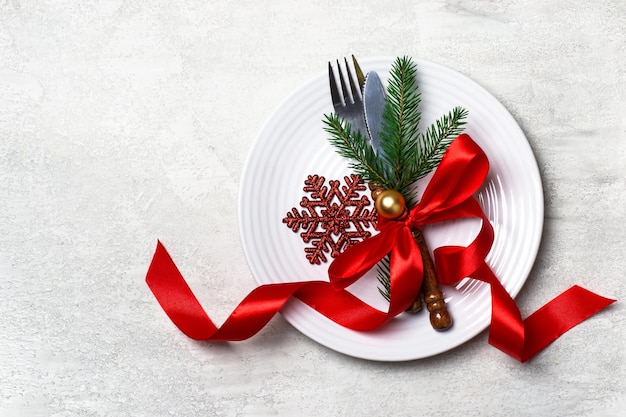 Ajuste de la mesa de navidad con adornos navideños cinta arco copo de nieve y bola