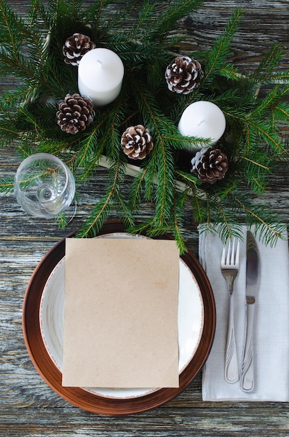 Ajuste de la mesa de Navidad con velas y ramas de abeto