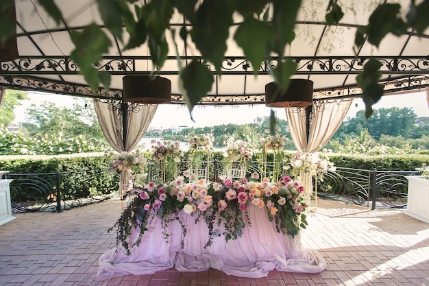 Ajuste de la mesa de la novia y el novio y decoración floral Baluarte de recién casados al aire libre