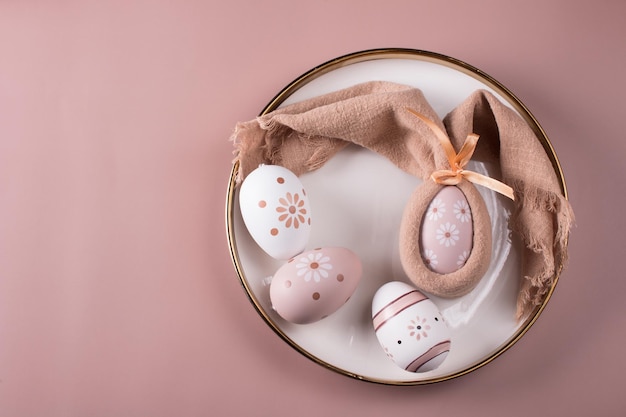 Ajuste de la mesa de Pascua Huevos de Pascua pintados en una vista superior de la placa blanca