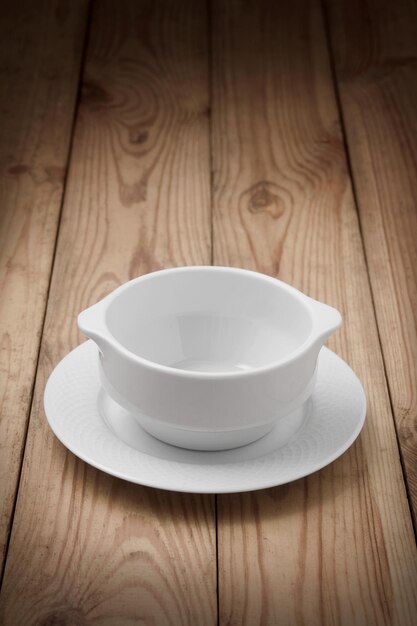 Ajuste de la mesa tazón de sopa vacío en la mesa de madera