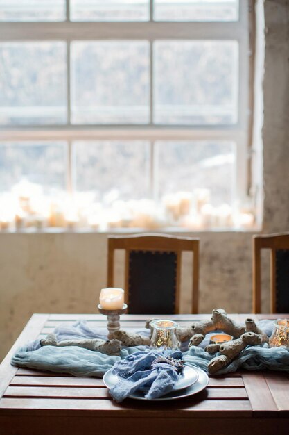 Ajuste de la mesa con velas y tejido azul.