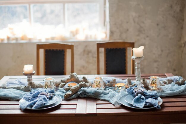 Ajuste de la mesa con velas y tejido azul.