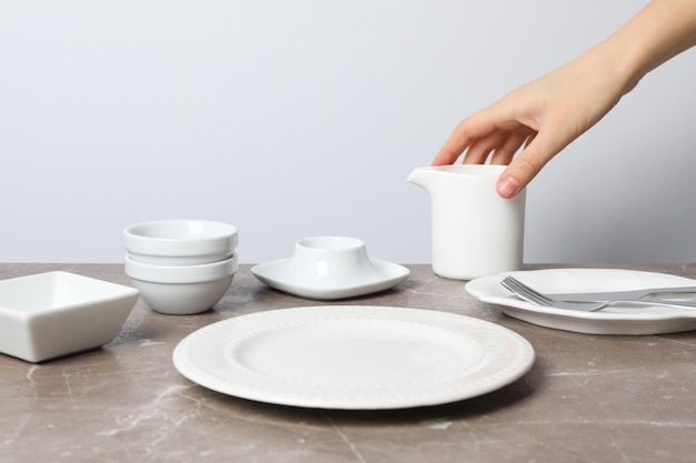 Ajuste mínimo de la mesa con un plato en blanco sobre una mesa gris texturizada