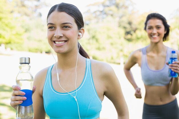 Ajuste a las mujeres con botella de agua para correr