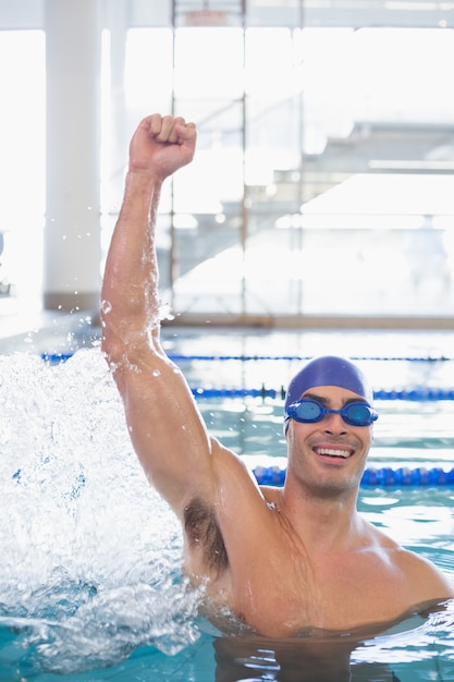 Ajuste nadador animando en la piscina en el centro de ocio