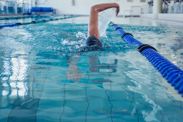 Ajuste nadador haciendo el golpe frontal en la piscina