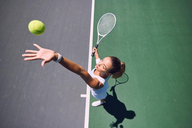 Ajuste o esporte do tenista e servindo durante o treino de treino e exercício ou jogo de partida e competição de cima Mulher ativa e saudável esportiva jogando uma bola e praticando saque com raquete