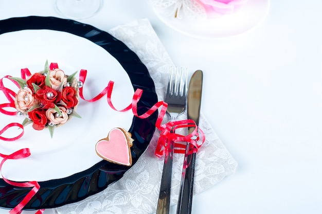 Ajuste romántico de la mesa con rosas rosadas