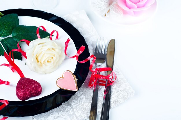 Ajuste romántico de la mesa con rosas rosadas