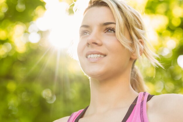 Ajuste rubia sonriendo en el parque