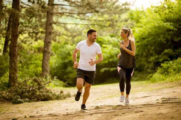 Ajuste saludable y pareja deportiva corriendo en la naturaleza.