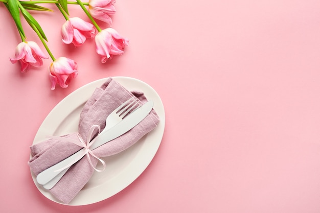 Ajuste de la tabla con decoración floral en mesa rosa