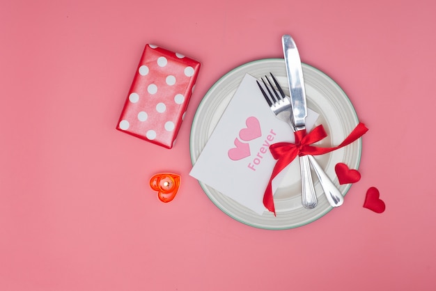 Ajuste de la tabla del día de San Valentín con placa sobre fondo rosa