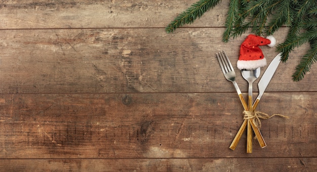 Ajuste de la tabla de navidad o año nuevo con cubiertos en la maqueta de plantilla de menú de mesa rústica de madera