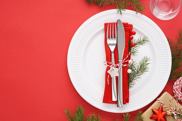 Ajuste de la tabla de Navidad con platos blancos, servilletas y cubiertos