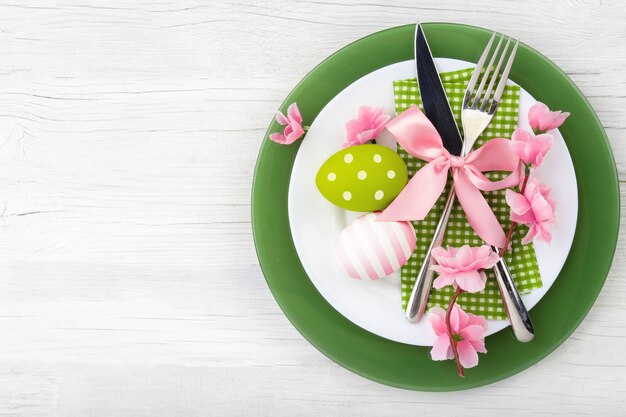 Ajuste de la tabla de Pascua con flores de primavera y cubiertos