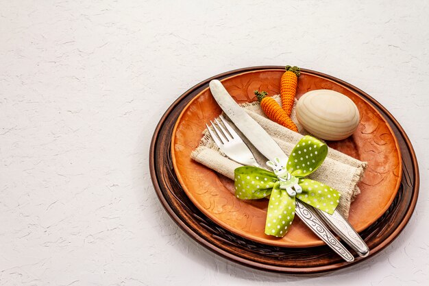 Ajuste de la tabla de Pascua en fondo blanco texturizado de la masilla. Plantilla de tarjeta de vacaciones de primavera. Cubiertos, servilletas vintage, huevo, zanahoria, conejito