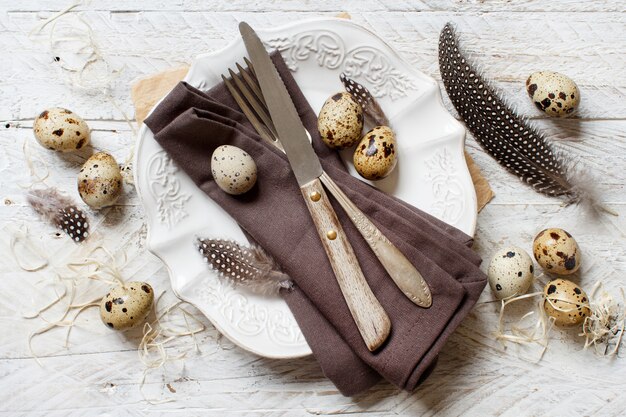 Ajuste de la tabla de Pascua con plumas y huevos de codorniz