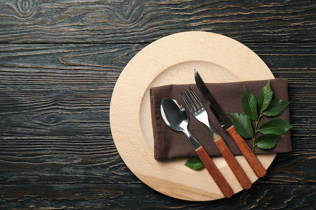 Ajuste de la tabla con plato de madera y cubiertos de madera