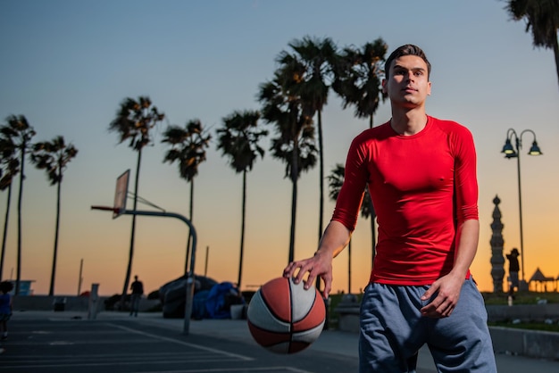 Aktionsaufnahme eines jungen Mannes, der im Freien Basketball spielt