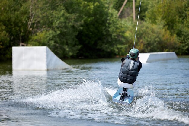 Aktionsfoto eines behinderten Mannes, der auf dem Wasser Wakeboard fährt