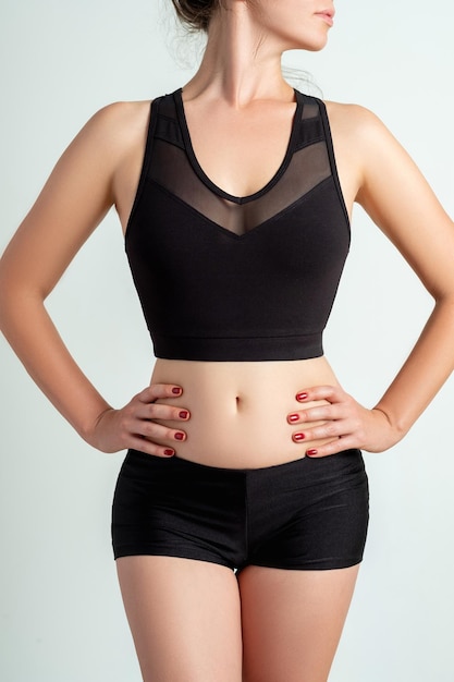 Aktive kleidung für damen. outfit-vorlage. trainingsdesign. schlanker körper der frau in logo-mockup-crop-top-shorts aus schwarzem mesh isoliert auf neutralem hintergrund.