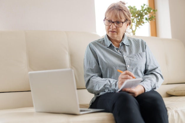 Aktive reife Frau, die einen Laptop für Remote-Arbeiten vom Home Office aus verwendet Videokonferenz-Videotreffen Leitender Lehrer leitet Webinar