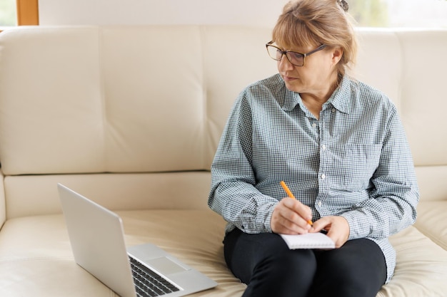 Aktive reife Frau, die einen Laptop für Remote-Arbeiten vom Home Office aus verwendet Videokonferenz-Videotreffen Leitender Lehrer leitet Webinar