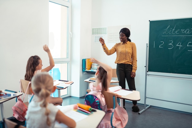 Aktive Schüler heben ihre Hände, während sie die Frage beantworten