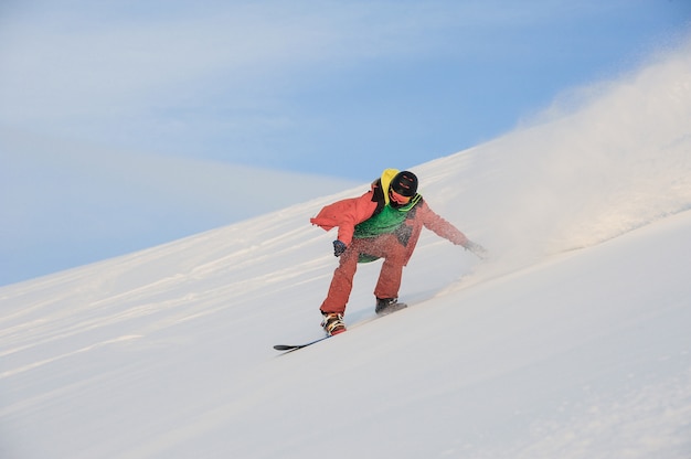 Aktive Snowboarder fahren auf der verschneiten Piste