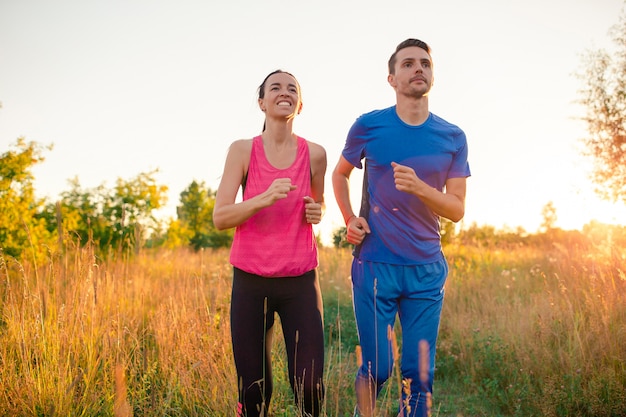 Aktive sportive Paare, die in Park laufen. Gesundheit und Fitness.