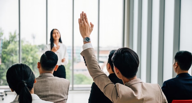 Aktive Teilnahme an einem Konferenzseminar in einem Klassenzimmer mit einer großen Gruppe, die die Hand hebt Die Antworten liegen im engagierten Publikum, was kollaboratives Lernen bedeutet