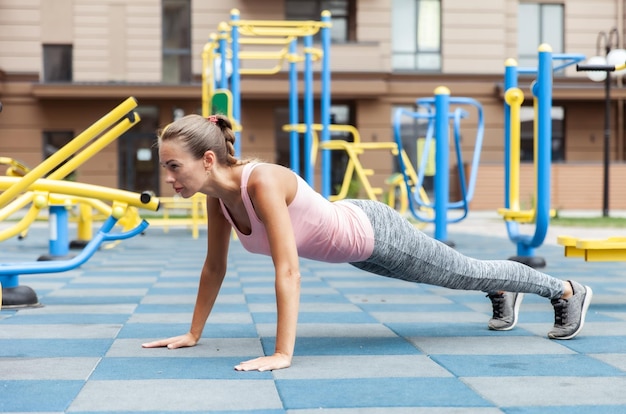 Aktiver Lebensstil Fit-Frauen-Push-Ups auf dem Outdoor-Workout-Spielplatz