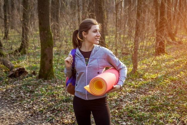 Aktiver Mädchenwanderer mit Rucksacktrekking durch den Wald