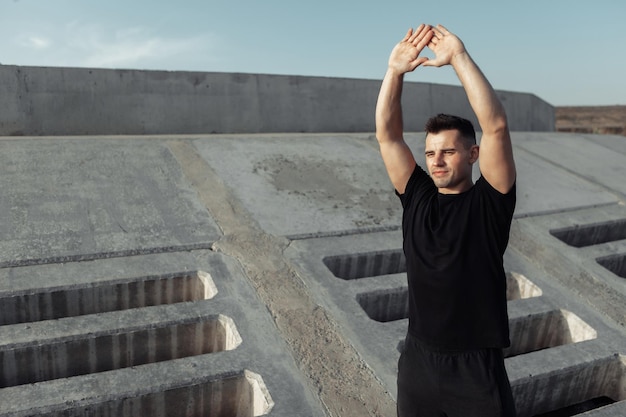 Foto aktiver muskulöser mann, der im freien auf betonplatten trainiert gesundes lifestyle-konzept