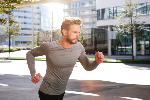 Aktiver Sportmann, der draußen in die Stadt läuft