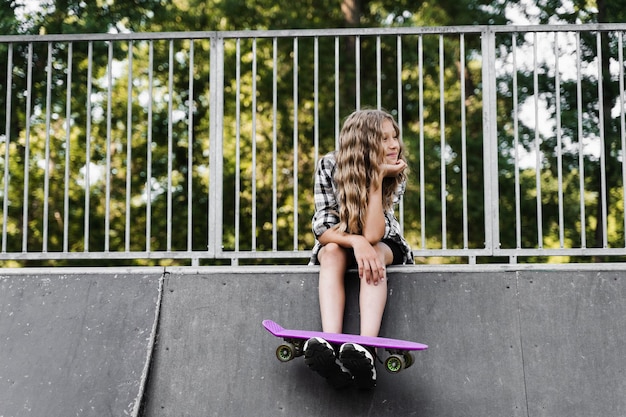 Aktives Kind mit Penny Board sitzt auf Skate-Sport-Rampe Extremer Sport-Lifestyle Kreative Werbung für Sportkinderladen