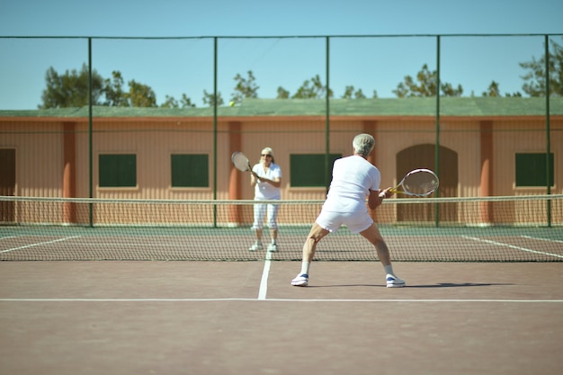 aktives Seniorenpaar auf einem Tennisplatz