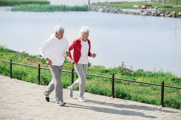 Aktives Seniorenpaar beim Joggen am See