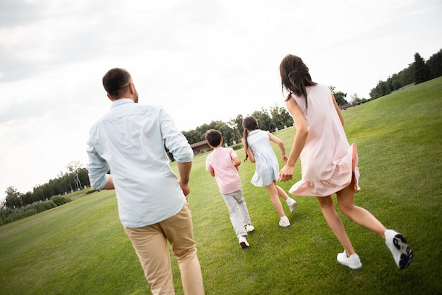 Aktives Wochenende Rückansicht der jungen Familie, die zusammen spielt, während sie Freizeit mit der Familie verbringt