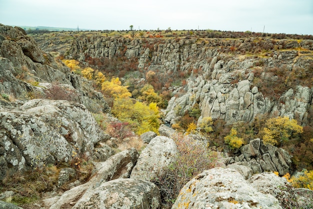 Aktovsky Canyon und Herbstbäume und große Steinblöcke herum